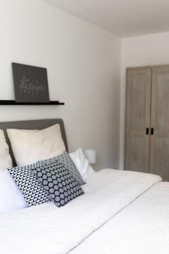 a white bed with two pillows on top of it at Ferienwohnung Steuerwald in Bobenheim am Berg