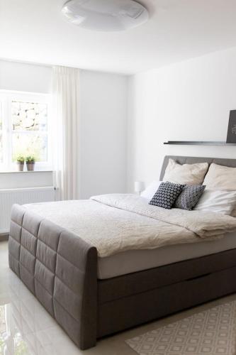 a white bedroom with a large bed with pillows at Ferienwohnung Steuerwald in Bobenheim am Berg