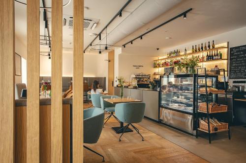 a restaurant with tables and chairs and a counter at Hotel Bronzo Brno in Brno
