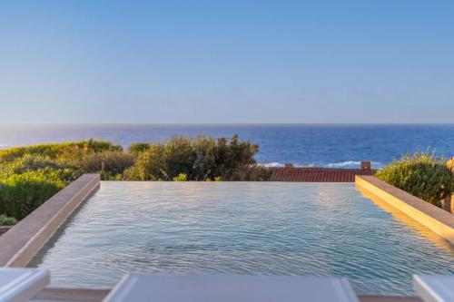 a swimming pool with the ocean in the background at Villa Vittoria - Costa Paradiso in Costa Paradiso