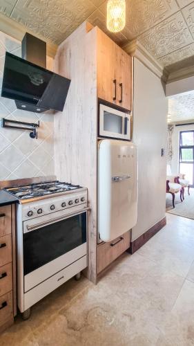 a kitchen with a stove and a refrigerator and a microwave at Batavia Boutique Hotel in Stellenbosch