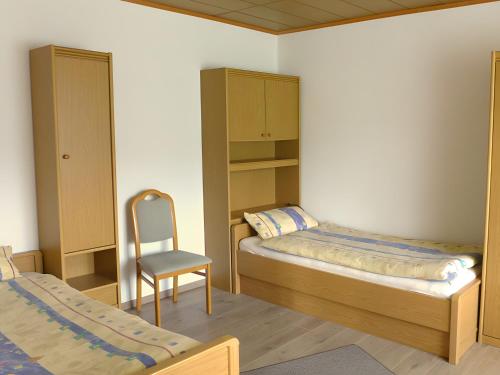 AlmeにあるFerienwohnung Hammerschmidtの小さなベッドルーム(ベッド2台、椅子付)