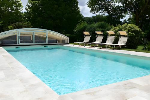 a swimming pool with chaise lounge chairs and a swimming pool at Gite La Clef Des Champs - Touraine in Tavant