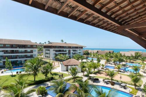 Cupe Beach Living Resort By Flatbpaiva في بورتو دي غالينهاس: منظر جوي للمنتجع مع المسبح والمحيط