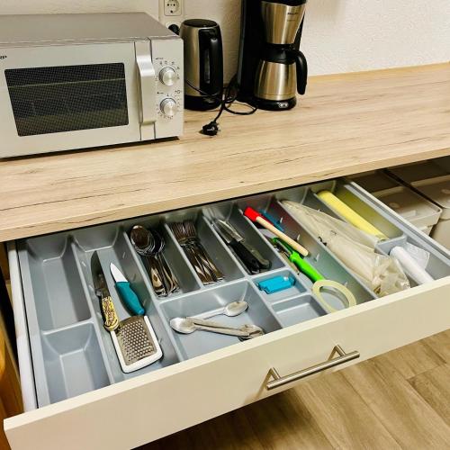 a drawer in a cabinet filled with kitchen utensils at Maxhaus 1 in Thüngen