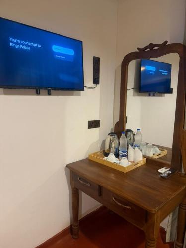 a room with a table with a mirror and a tv at King's Palace in Kandy
