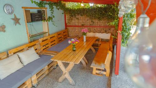 a wooden table with a bench and flowers on it at Vila Familia in Turčianske Teplice