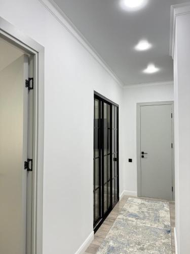 an empty hallway with white walls and a mirror at Asel Residential Complex, stylish 3-room apartment in Atyraū