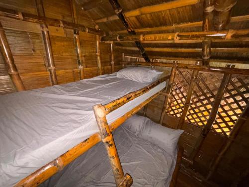 a bunk bed in a wooden room with a bed at Bill and Yen Agri Tourism Park 