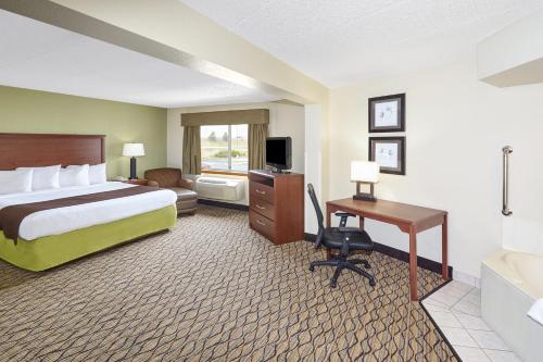 a hotel room with a bed and a desk at AmericInn by Wyndham Sheboygan in Sheboygan