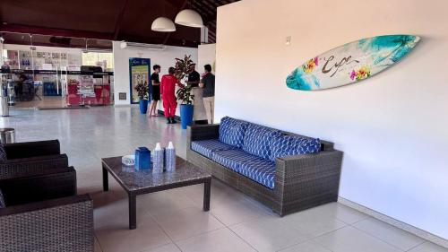 Cupe Beach Living Resort By Flatbpaiva في بورتو دي غالينهاس: ردهة بها أريكة ولوح ركوب الأمواج على الحائط