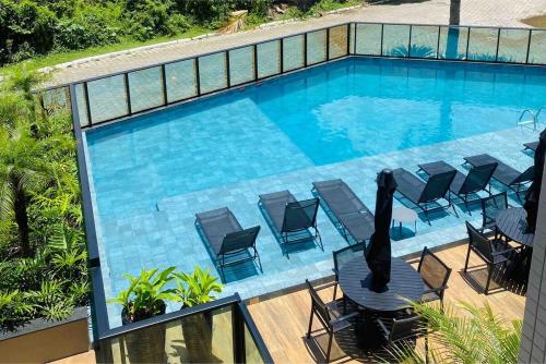 an infinity swimming pool with chairs at Brava Paradise in Cabeçudas