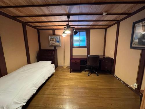a bedroom with a bed and a desk and a chair at 緋乃里 in Wada
