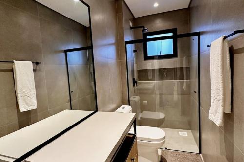 a bathroom with a toilet and a glass shower at Brava Paradise in Cabeçudas