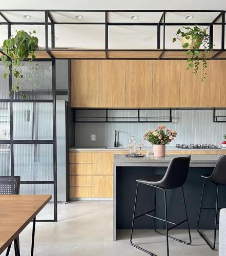 a kitchen with wooden cabinets and a counter with chairs at Brava Paradise in Cabeçudas