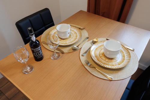a table with plates and glasses and a bottle of wine at Green Shelter - Guest House in Santana