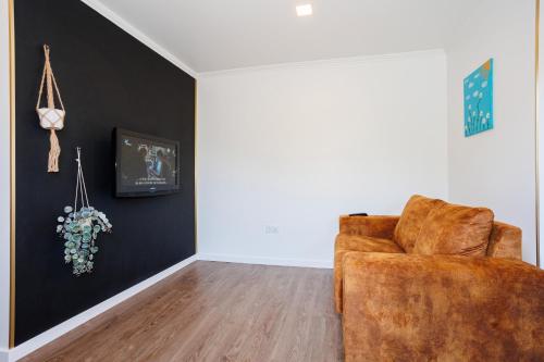 a living room with a brown chair and a wall at Green Shelter - Guest House in Santana
