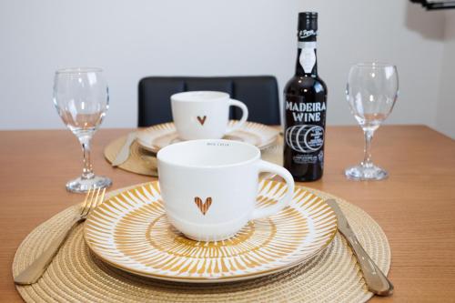 a table with plates and cups and a bottle of wine at Green Shelter - Guest House in Santana
