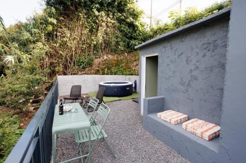 a patio with a table and chairs and a hot tub at Green Shelter - Guest House in Santana