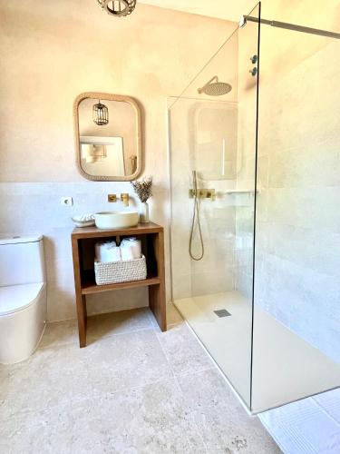 a bathroom with a glass shower and a sink at El Torreón de Cepones in Segovia