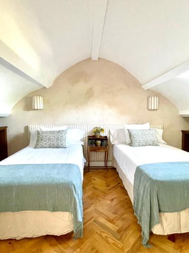 two beds sitting next to each other in a bedroom at El Torreón de Cepones in Segovia