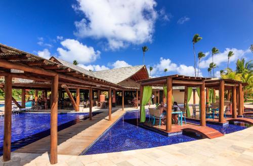 a pool at a resort with wooden pavilion at Vivá Porto de Galinhas Resort in Porto De Galinhas