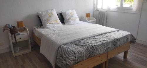 ein Schlafzimmer mit einem großen Bett mit weißen Laken und Kissen in der Unterkunft Hébergement tout confort dans logement proche de la gare in Montpellier