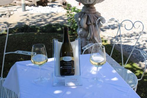 a bottle of wine and two glasses on a table at Giuliva B&B in Refrontolo