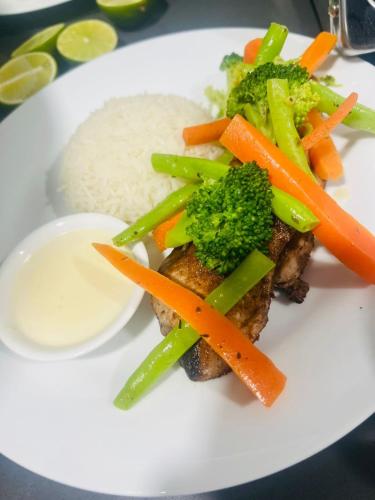 a plate of food with broccoli carrots and rice at Futtaru Sands in Gaafaru