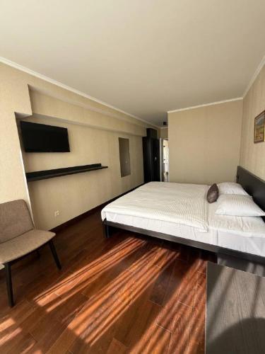 Un dormitorio con una cama grande y una silla. en Shirak Hotel, en Ereván
