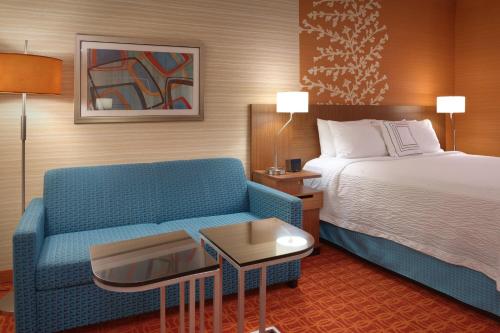 a hotel room with a bed and a blue couch at Fairfield Inn & Suites by Marriott Salt Lake City Downtown in Salt Lake City