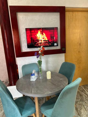 a table and chairs with a fireplace in a room at Appartment calme a Ain Aouda in Aïn el Apuda