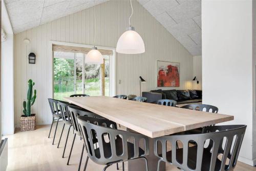 a dining room with a large wooden table and chairs at 20864-Ulfborg-Vederso-Klitvej-37-E in Vedersø Klit