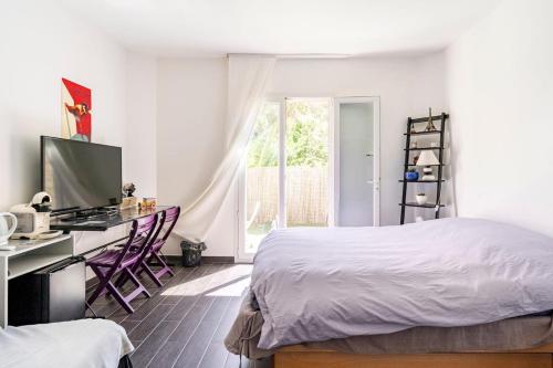a bedroom with a bed and a desk with a computer at Chambre avec entrée indépendante-Jardin privé- 200m des plages in Théoule-sur-Mer