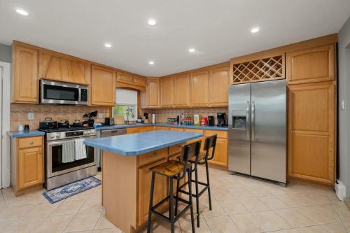 a kitchen with wooden cabinets and stainless steel appliances at 3BR Apt Near Train Balcony Yonkers in Yonkers