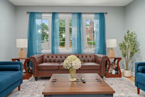 a living room with a brown couch and blue curtains at 3BR Apt Near Train Balcony Yonkers in West Mount Vernon