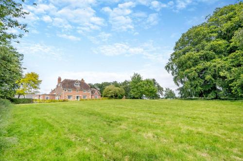an open field with a large house in the background at Park Farmhouse in Kimberley