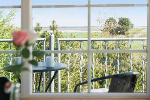 a window with a table and a view of a field at 30876-Ulfborg-Krogsgardvej-5 in Sønder Nissum