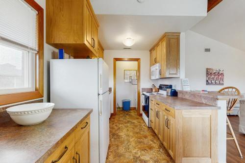 a kitchen with a white refrigerator and wooden cabinets at Steer 553 in Frisco