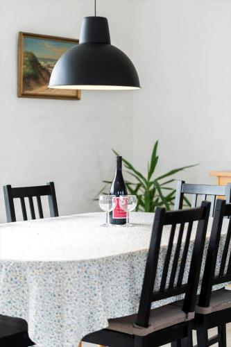a bottle of wine sitting on a table with chairs at 70099-Ulfborg-Klitrosevej-2 in Thorsminde