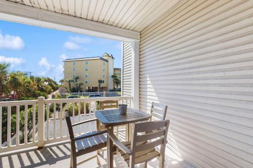 a table and chairs on a balcony with a view of a building at Pier Pointe Villas C102 in Folly Beach