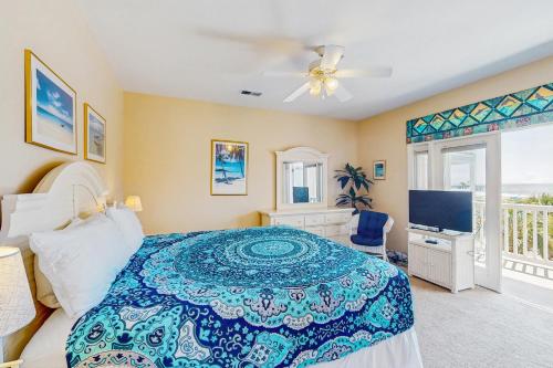 a bedroom with a bed and a tv and a window at Pier Pointe Villas C102 in Folly Beach
