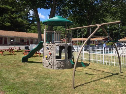 a playground in a park with a swing at Marcotte Motor Court in Old Orchard Beach