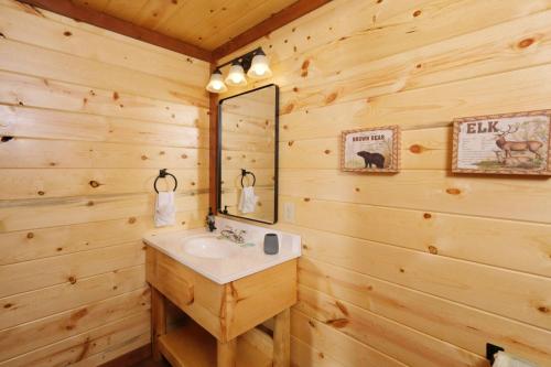 łazienka z umywalką i lustrem w obiekcie Whispering Pines Escape - Private Pool, Theater Room, Outdoor Hot Tub + Game Room w mieście Sevierville