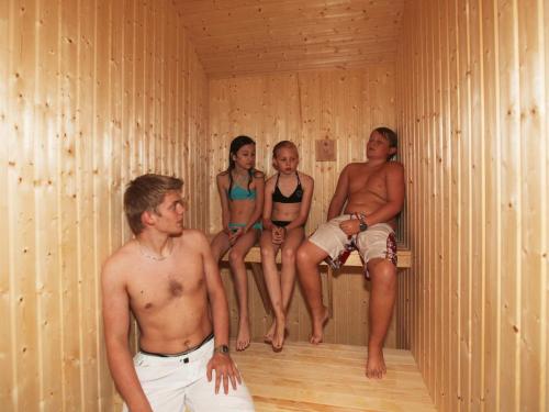 a group of people sitting in a sauna at Luxury Retreat with Pool - By Traum Ferienwohnungen in Tisvildeleje
