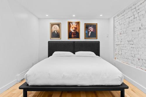 a bed in a room with four pictures on the wall at Le Chateau de Pierre in Quebec City