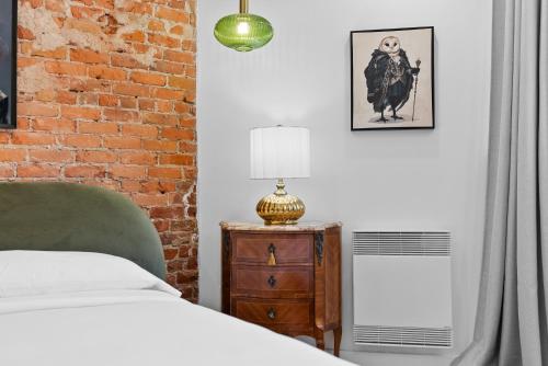 a bedroom with a bed and a brick wall at Le Chateau de Pierre in Quebec City