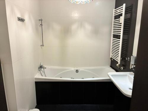 a bathroom with a bath tub and a sink at Deluxe Apartament na wyłączność z darmowym parkingiem w garażu fv in Warsaw