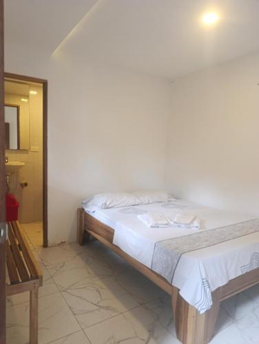 a bedroom with a bed with white sheets at Hermoso Palomino in Palomino