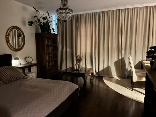 a bedroom with a bed and a table and a window at Deluxe Apartament na wyłączność z darmowym parkingiem w garażu fv in Warsaw